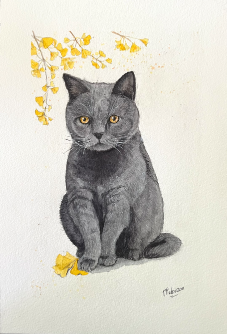 Portrait sur commande d'un chat gris aux yeux dorés, assis parmi des feuilles jaunes.